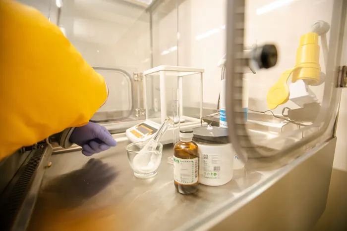 Pharmacist compounding a custom medication inside a laminar flow hood