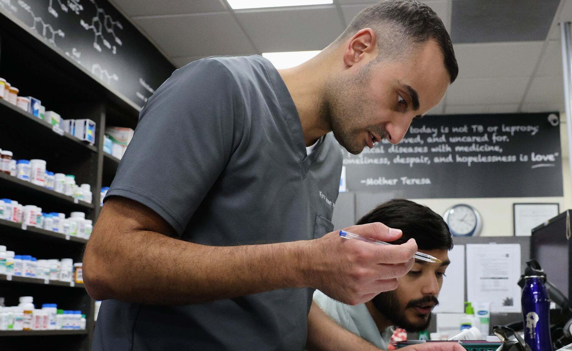 Pharmacist reviewing a patient's medication with two team members